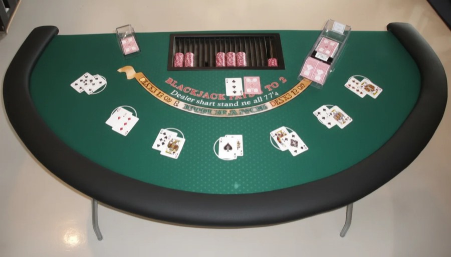 Mesa de blackjack con el letrero de reglas impreso en el tapete